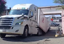 Tráiler quedas atorado en puente ferroviario